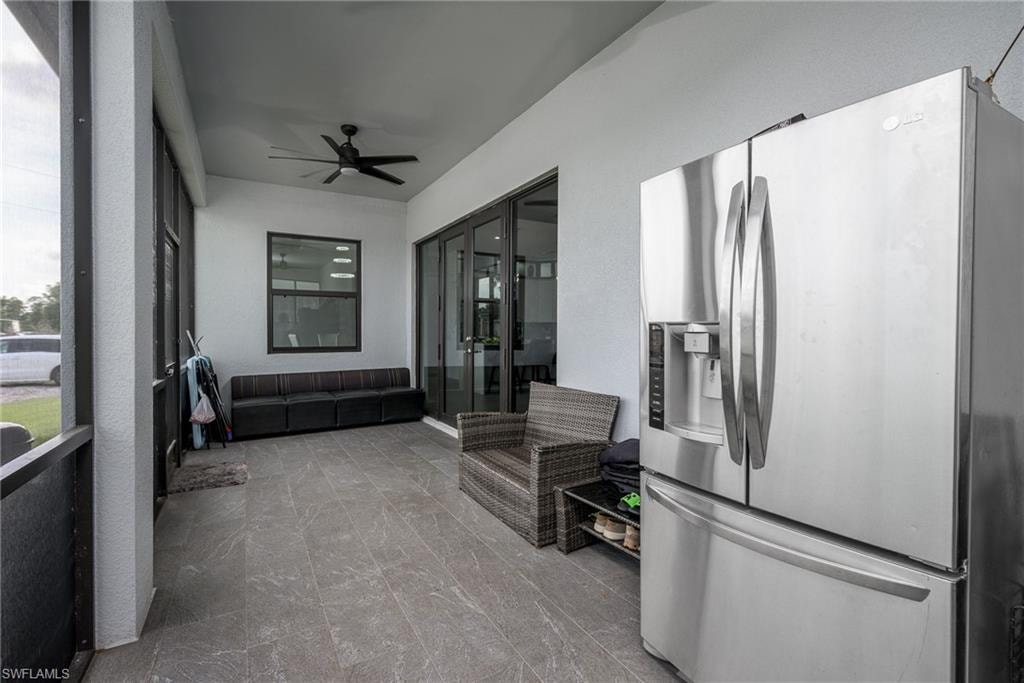 Screened outdoor living area featuring a ceiling fan, matte black framed window, and bifold glass doors