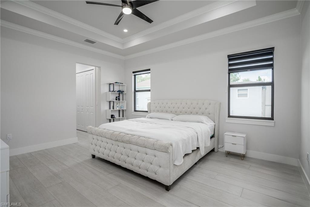 Spacious interior featuring a decorative tray ceiling with recessed lighting and a ceiling fan
