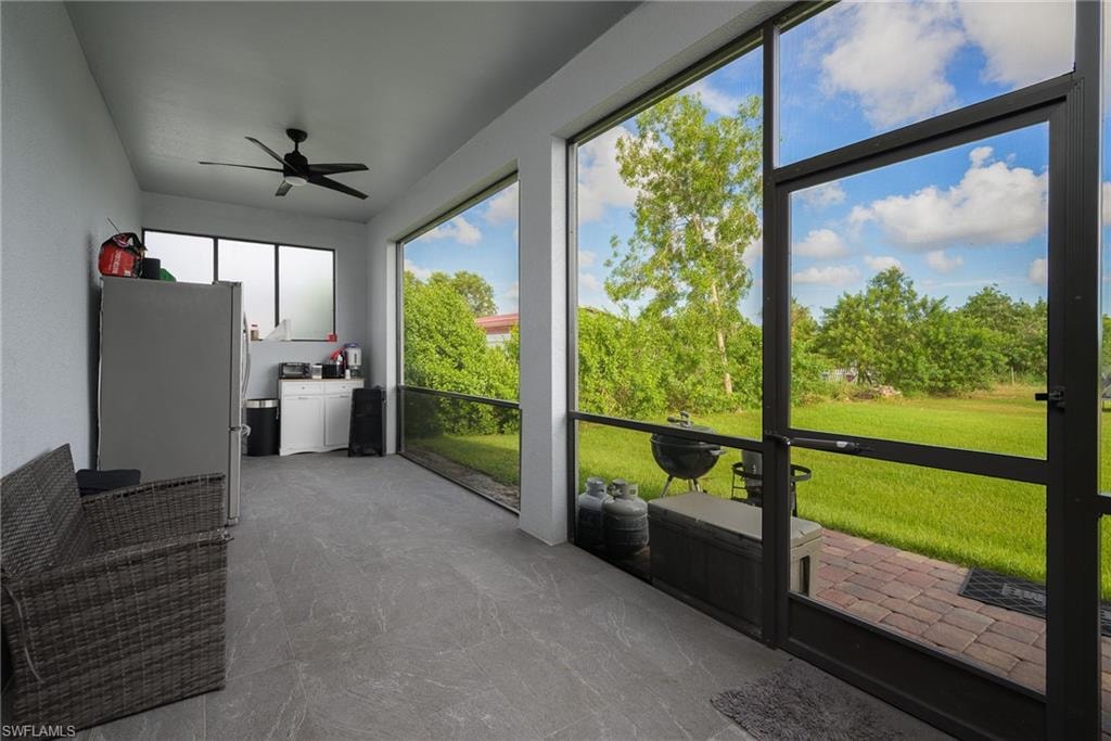 Screened outdoor living area featuring a ceiling fan, recessed lighting, and a durable tile flooring
