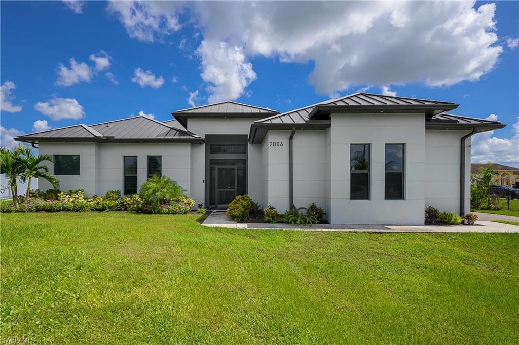 Contemporary stucco exterior with a multi-gabled metal roof