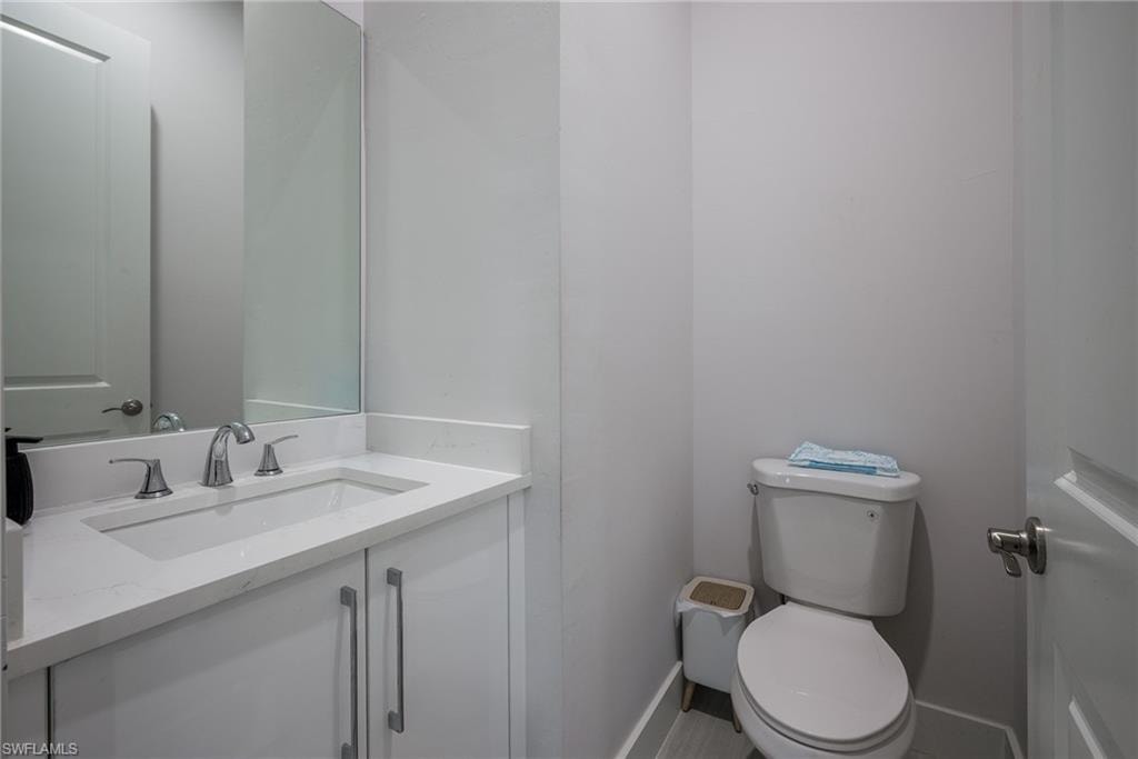 Bathroom featuring a white vanity with an integrated sink, polished chrome faucet, and white quartz countertop