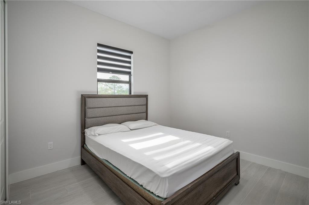 Bright room featuring light gray walls, a window with horizontal blinds, and light-toned tile flooring