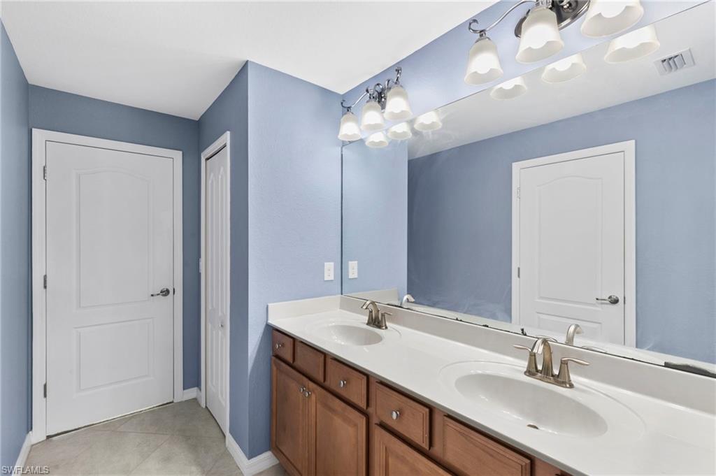 Jack and Jill bathroom with dual vanities and tub/shower combo.