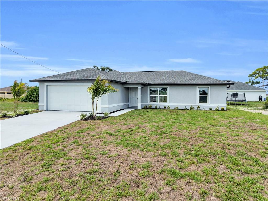 Single-story residence featuring a light gray stucco exterior with white trim