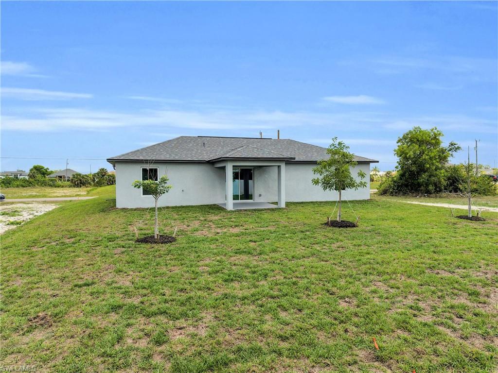 Contemporary stucco exterior with a dark shingle roof, featuring a covered patio
