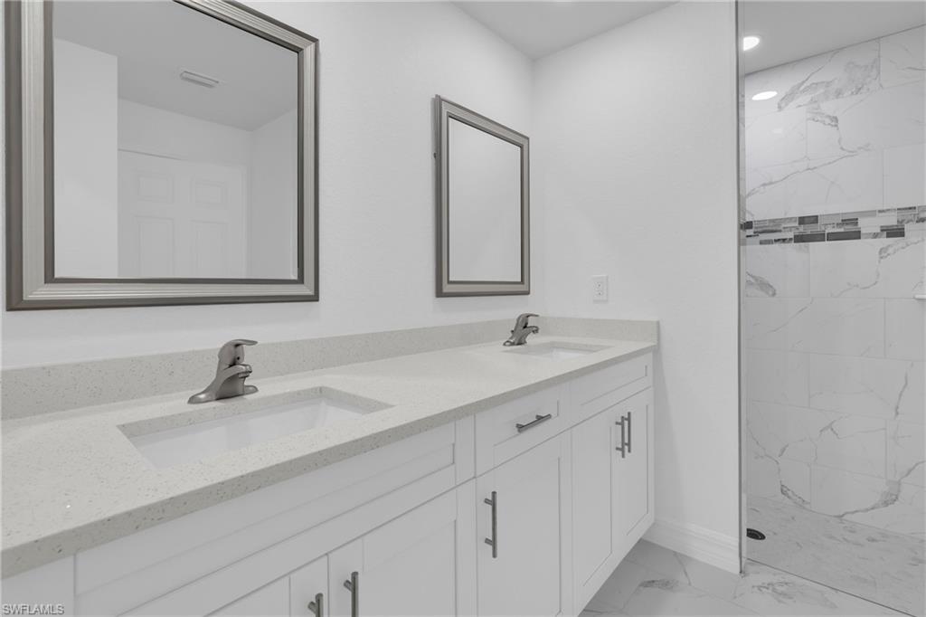 Dual vanity featuring solid surface countertops, undermount sinks, and brushed nickel fixtures