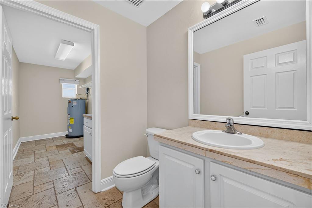 Common area half bathroom with laundry and utility room beyond