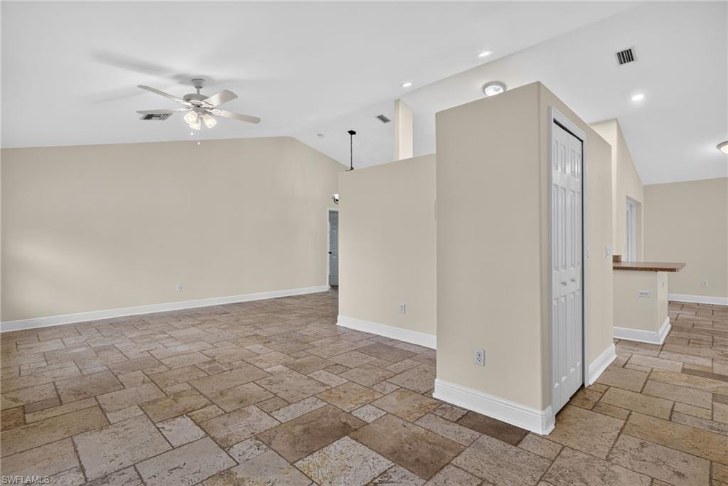 Entryway with front living room to left, coat closet center, and passage to kitchen and rear living room on right