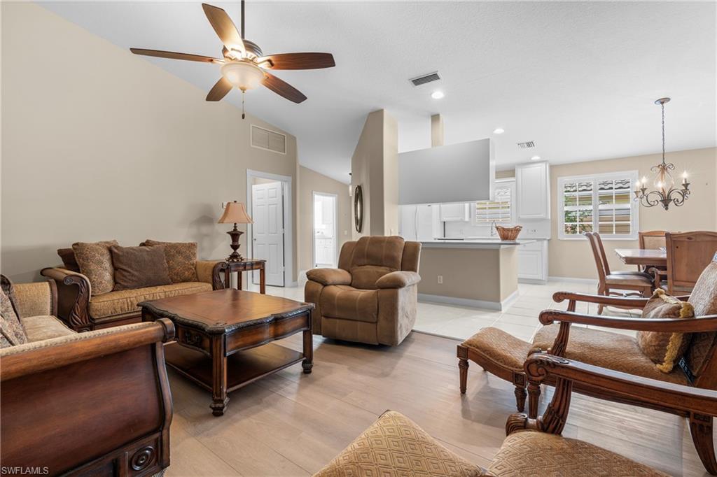 Open concept living area featuring vaulted ceilings and wood-finish flooring