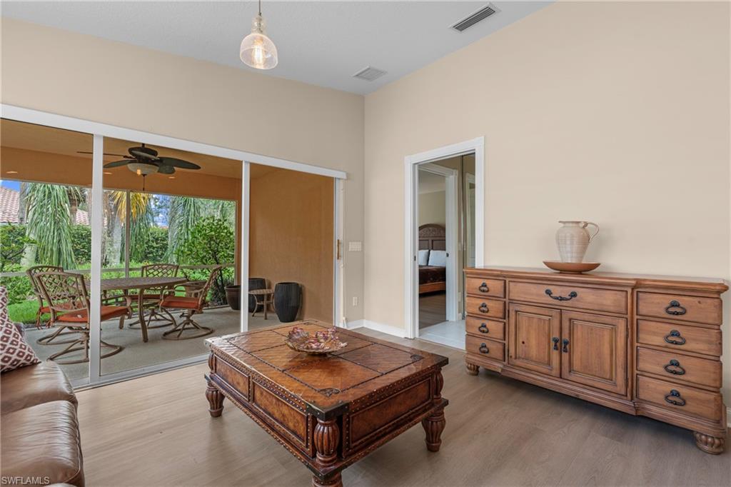 Spacious interior featuring light tone wood-finish flooring and a covered outdoor patio
