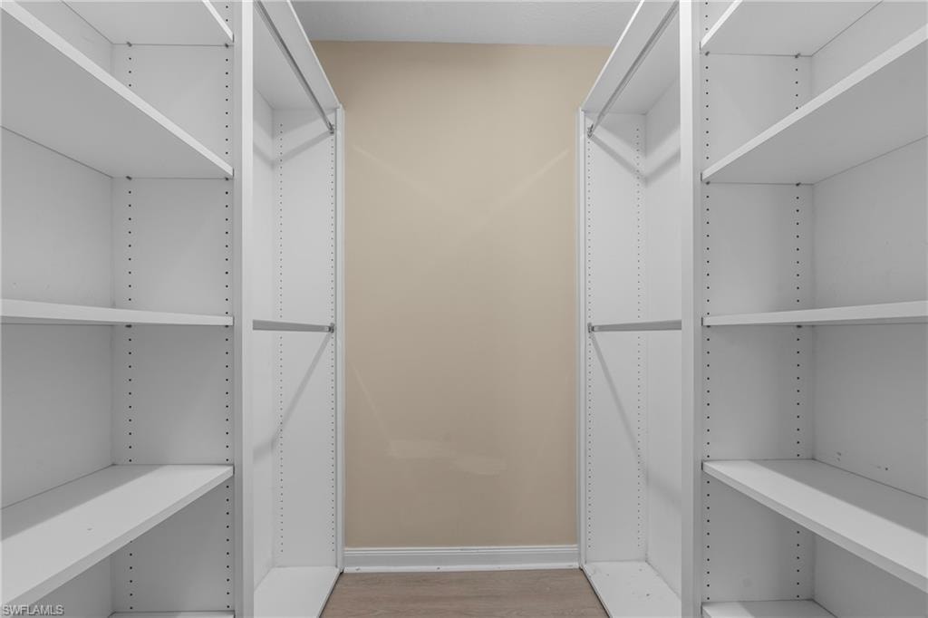 Custom closet system featuring white shelving and hanging rods