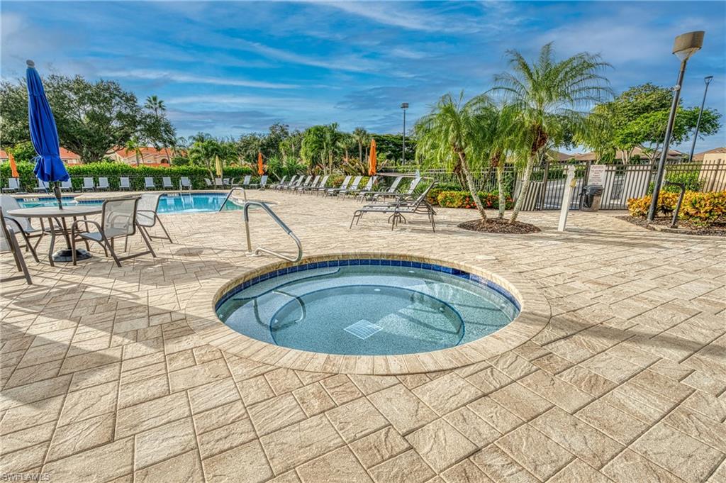 Circular spa with blue tile accents and integrated steps
