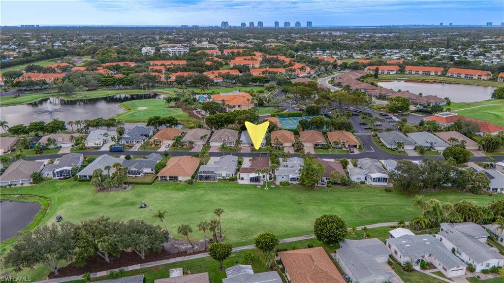 Residential property bordering a golf course, featuring a landscaped yard with mature trees