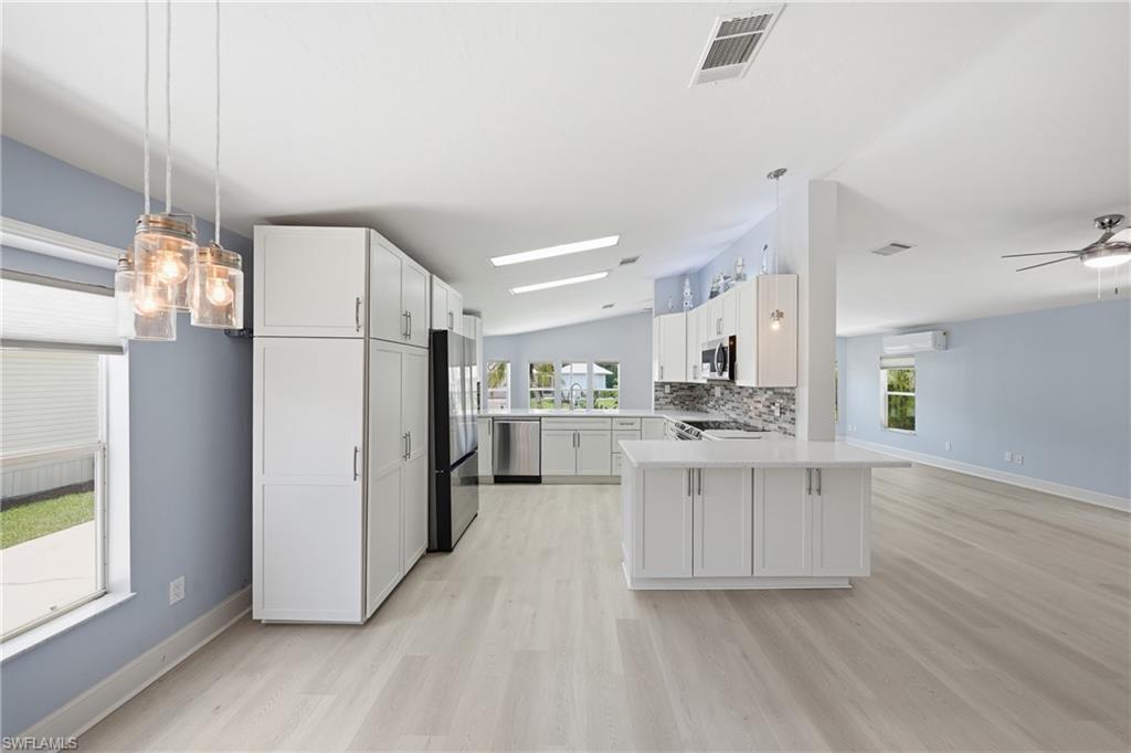 Open-concept kitchen with white cabinetry and a central island