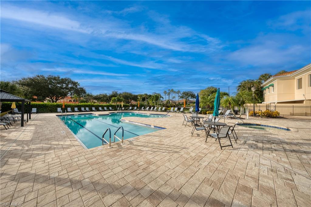 Expansive outdoor pool area featuring a rectangular main pool and a smaller, irregularly shaped pool
