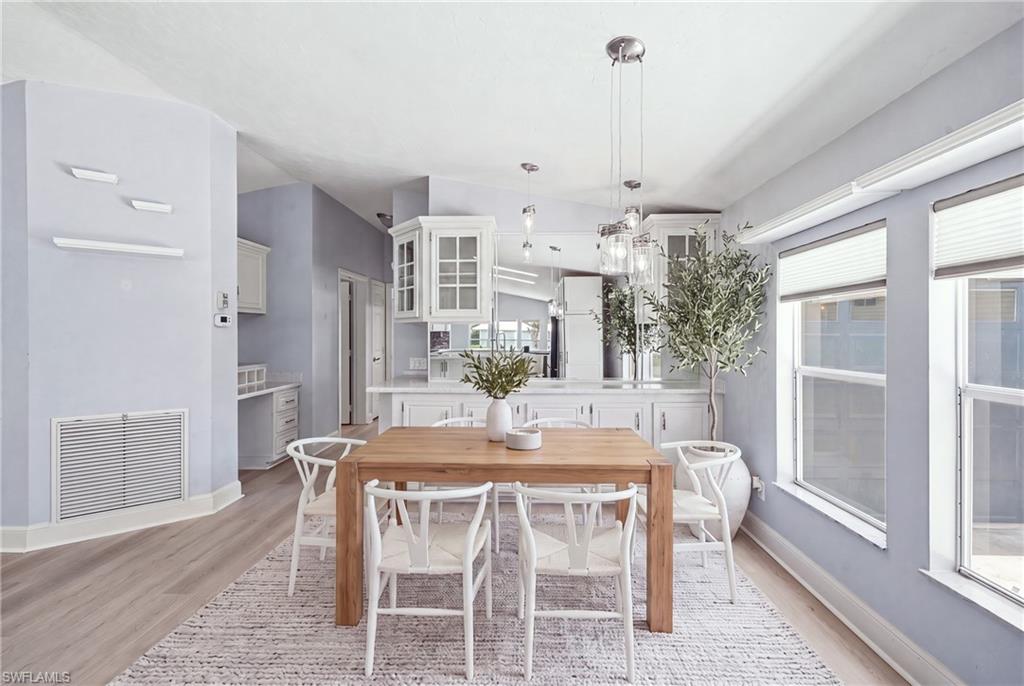 Dining area featuring wood-finish flooring and a contemporary linear chandelier