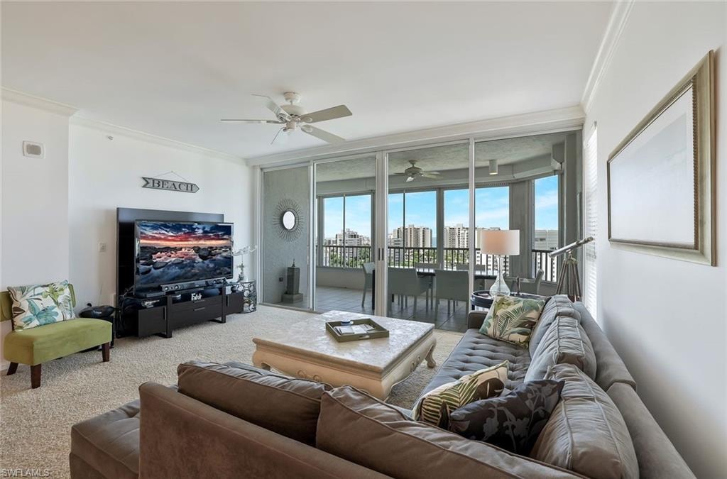 Living room featuring plenty of natural light, crown molding, a ceiling fan, carpet, and expansive windows