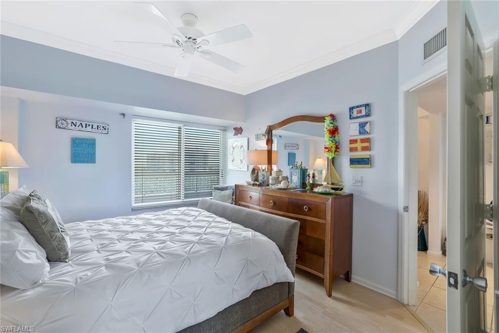 Bedroom with crown molding, light wood finished floors, and a ceiling fan
