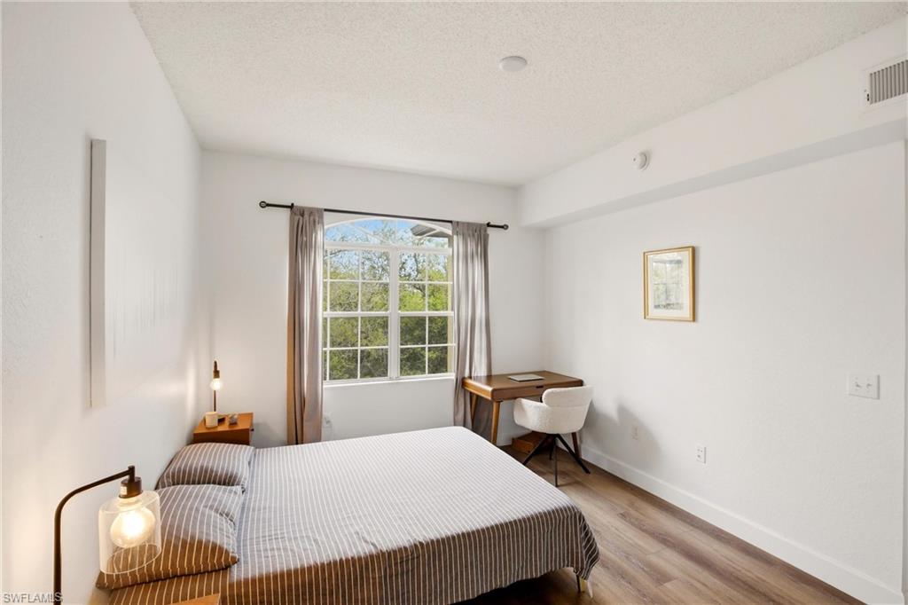 Bedroom with wood finished floors and a textured ceiling