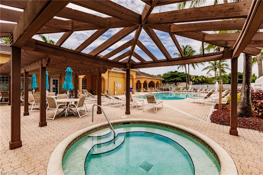 Community pool featuring a patio, a hot tub, and outdoor dining space