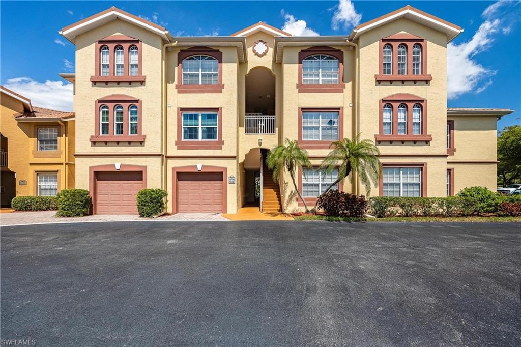 Mediterranean / spanish-style house with stucco siding, driveway, and an attached garage