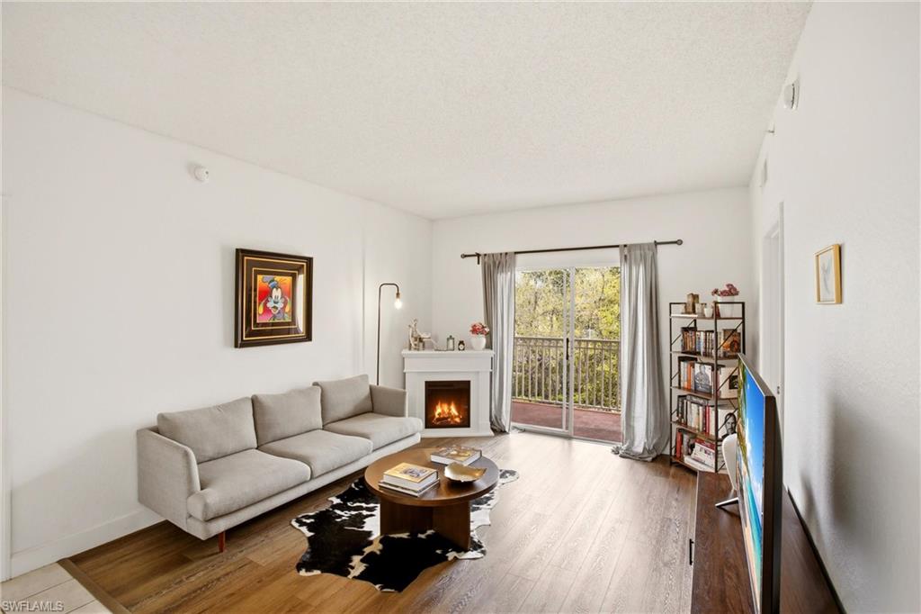 Living room featuring wood-type flooring and a warm lit fireplace