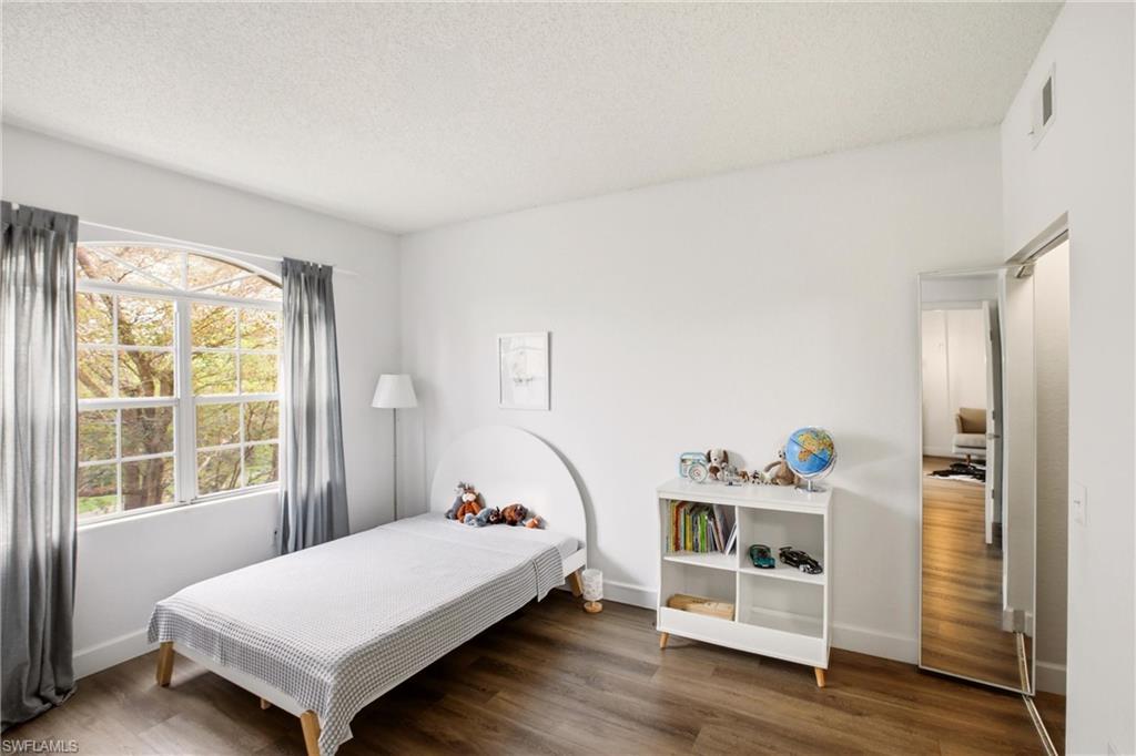 Bedroom featuring dark wood-style flooring and a textured ceiling