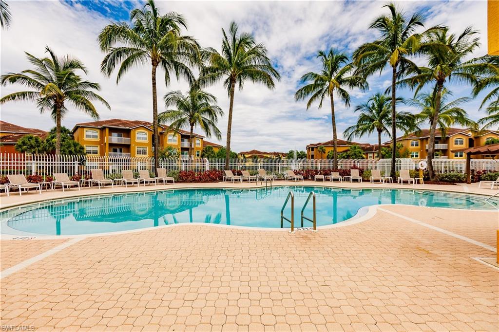 Community pool with a patio area and a residential view