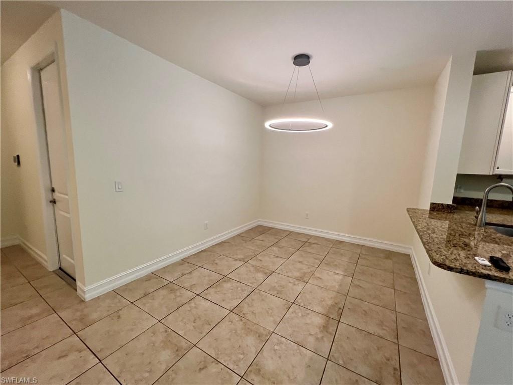 Unfurnished dining area featuring sink and light tile patterned floors