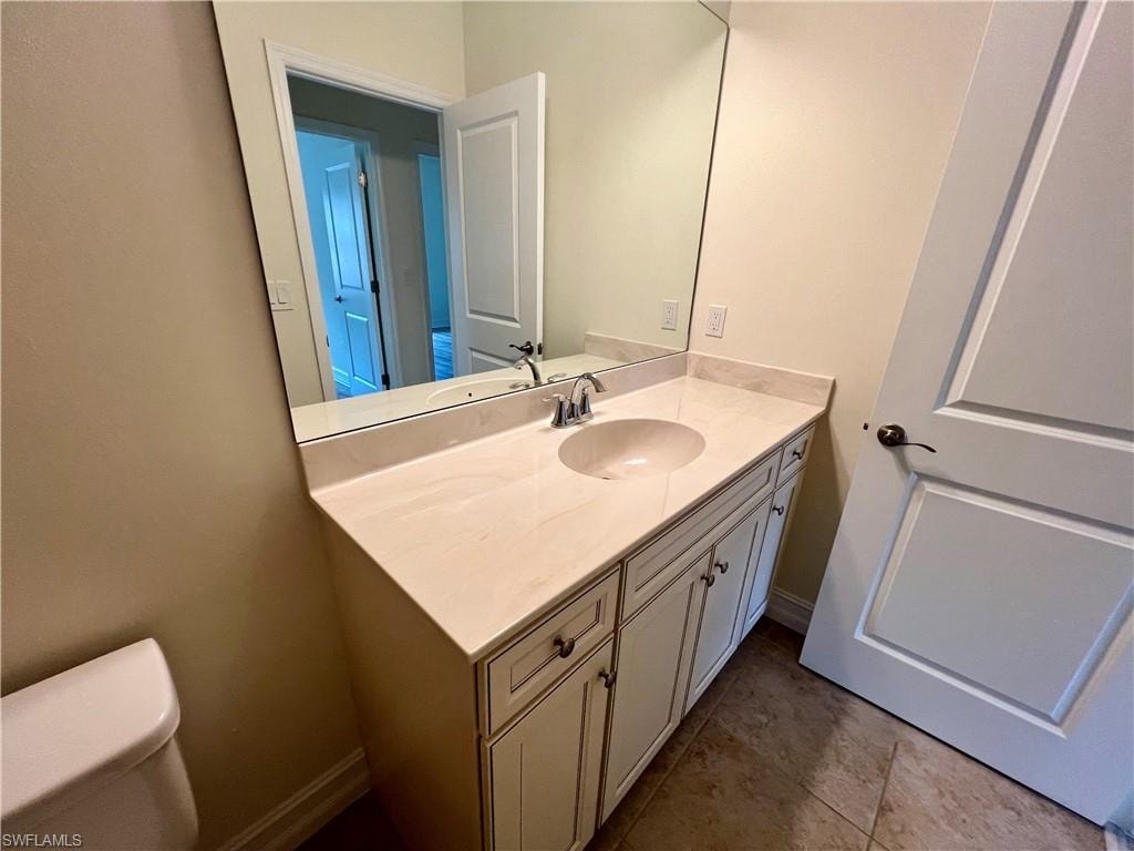 Bathroom with vanity, tile patterned floors, and toilet