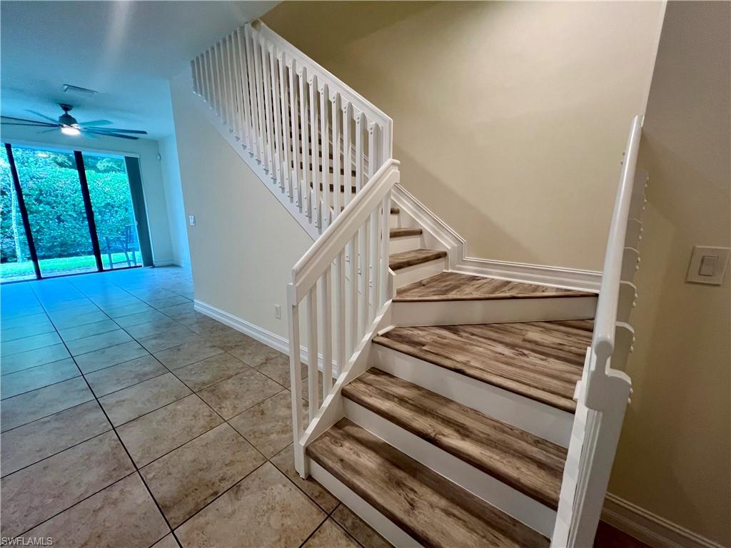 Stairway with ceiling fan and light tile patterned floors