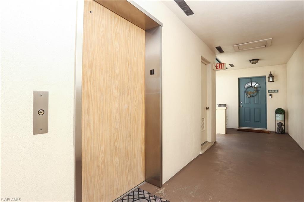 Hall with concrete flooring and elevator