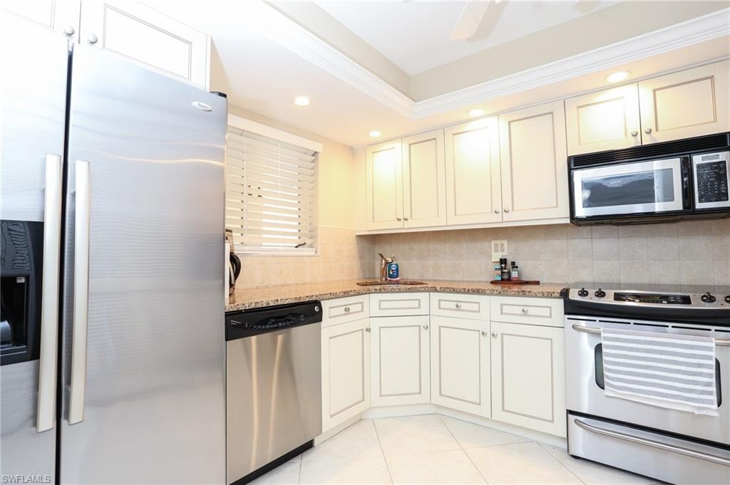 Kitchen with recessed lighting, a sink, light tile patterned flooring, tasteful backsplash, and appliances with stainless steel finishes