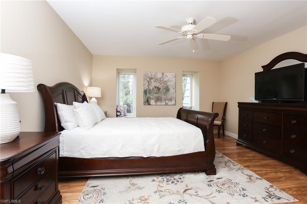 Bedroom featuring a ceiling fan, baseboards, and light wood-style floors