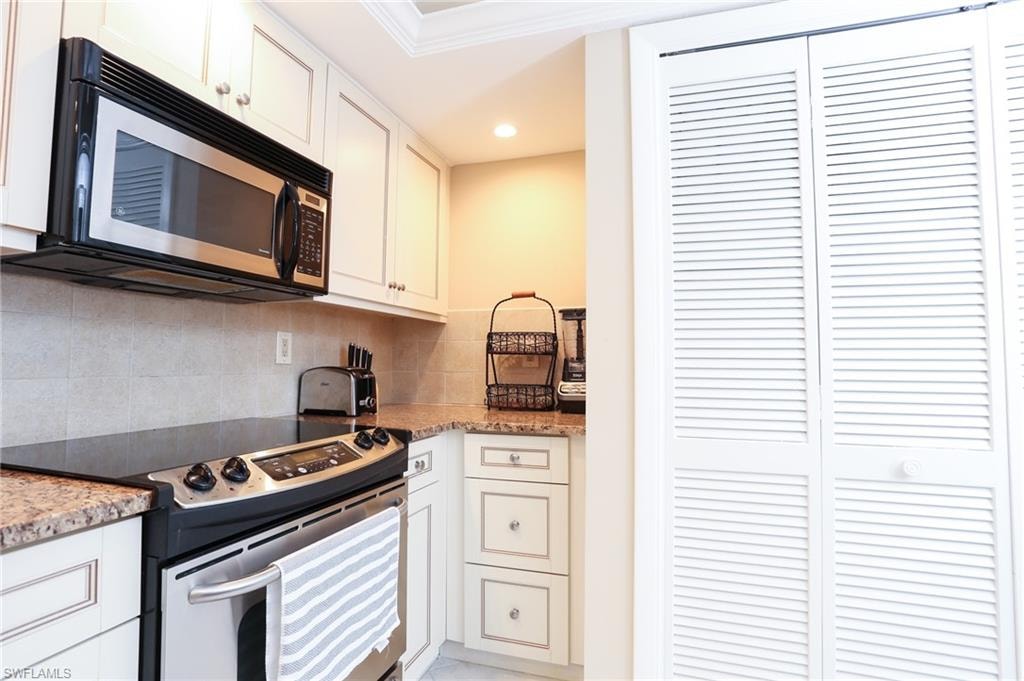 Kitchen with white cabinets, tasteful backsplash, appliances with stainless steel finishes, and recessed lighting