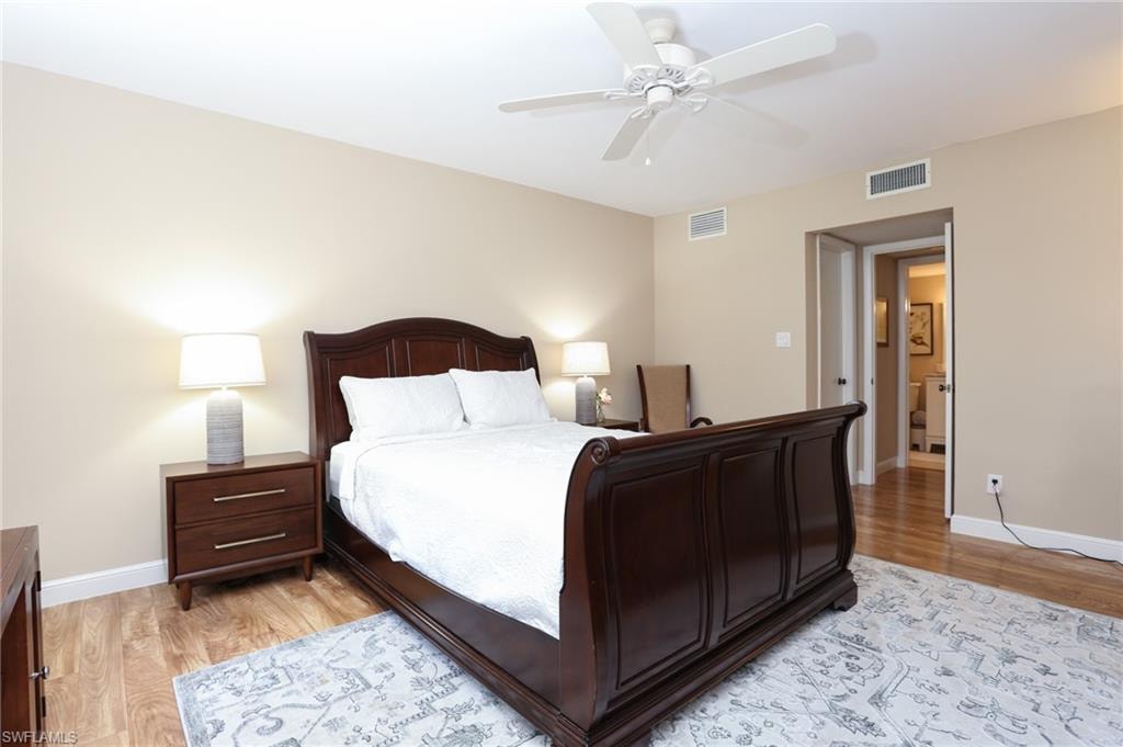 Bedroom featuring light wood finished floors, baseboards, and visible vents