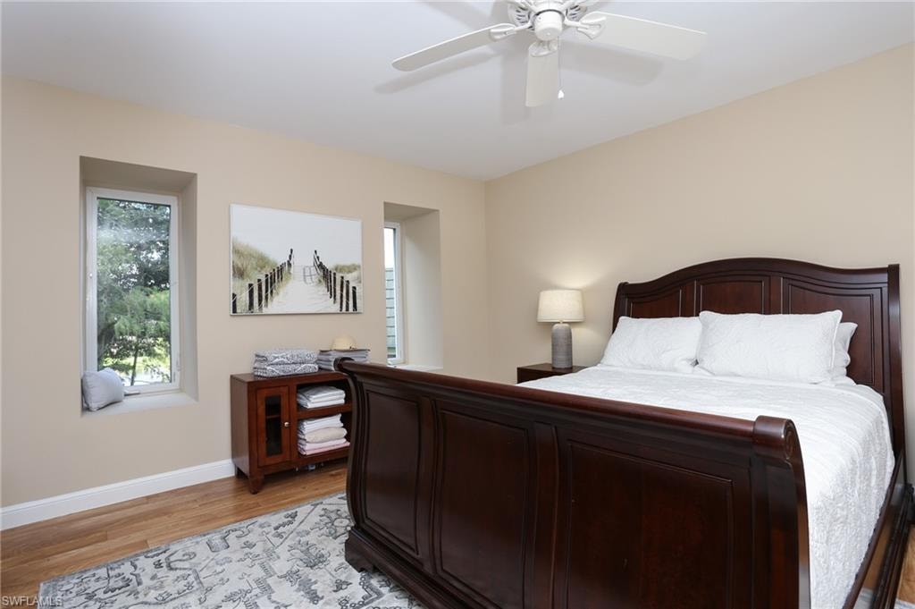 Bedroom with light wood-style flooring, baseboards, and a ceiling fan