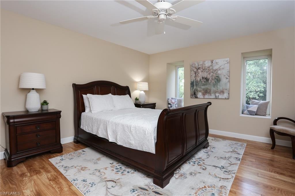 Bedroom with baseboards, a ceiling fan, and light wood-style flooring