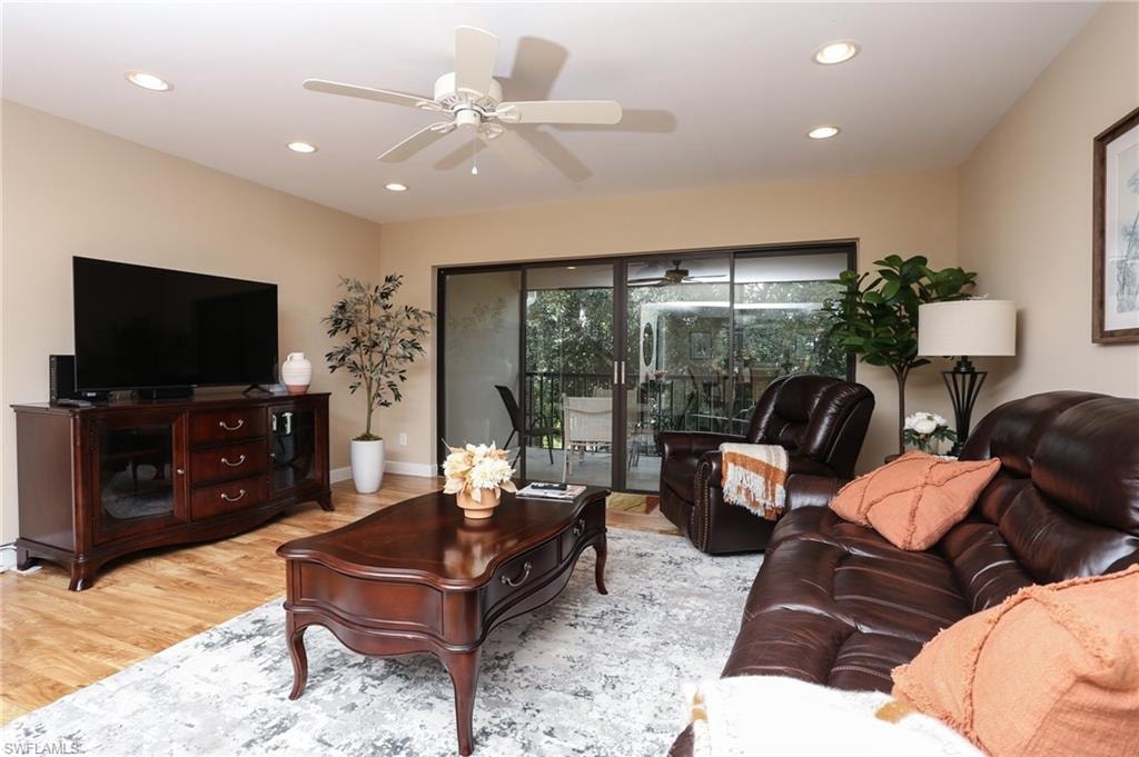 Living room with ceiling fan, baseboards, wood finished floors, and recessed lighting