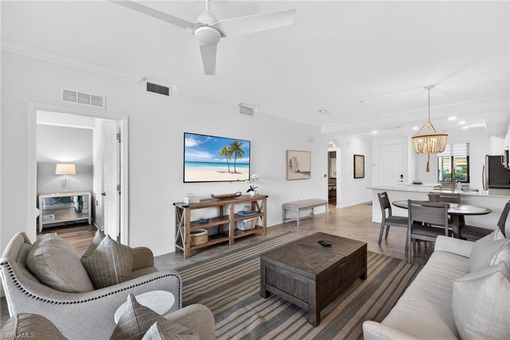 Open-concept living area featuring a ceiling fan, recessed lighting, crown molding, and light-toned flooring