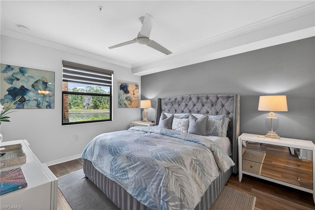 Bedroom featuring a large window with horizontal blinds, wood-finish flooring, a contemporary ceiling fan, and crown molding