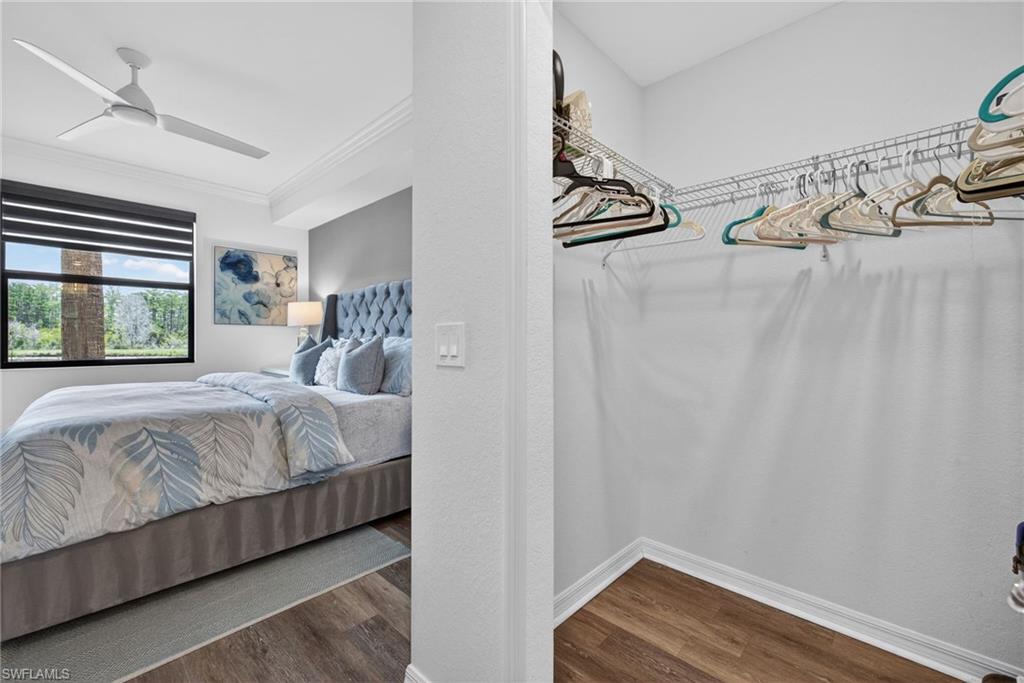 Bedroom featuring wood-finish flooring, a contemporary ceiling fan, and crown molding