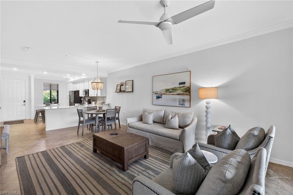 Open-concept living area with tile flooring and crown molding