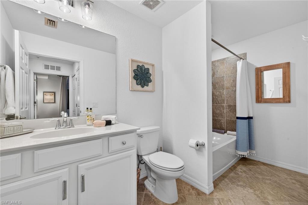 Bathroom featuring a white vanity with an integrated sink, polished chrome faucet, and overhead lighting