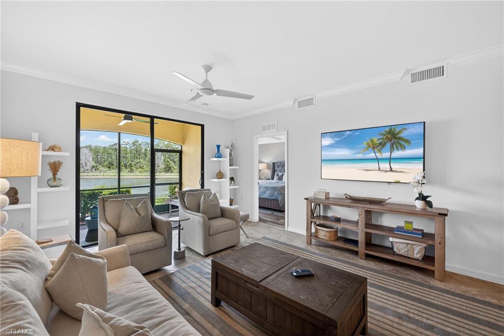 Living area featuring a spacious screened-in patio overlooking a body of water and natural landscape