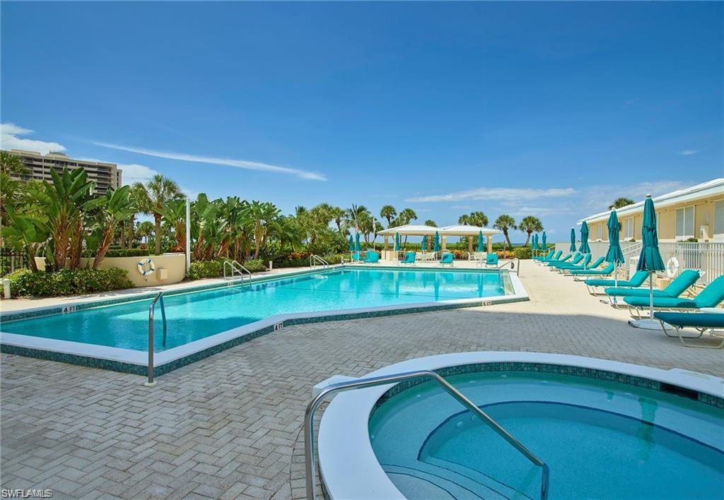 View of swimming pool featuring a community hot tub and a patio