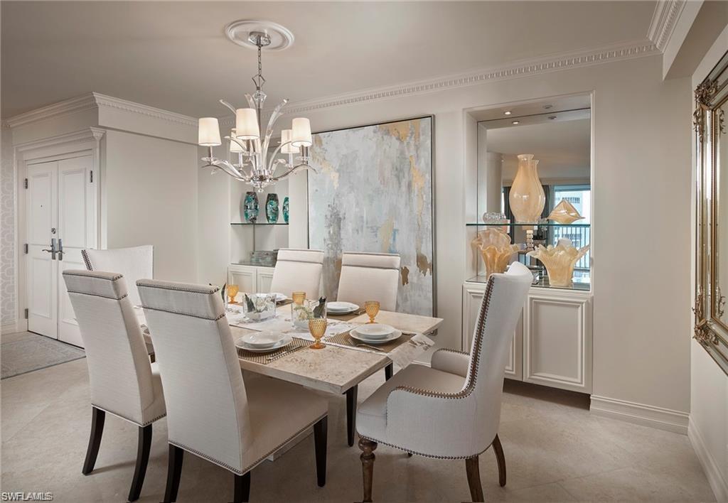 Dining space featuring an inviting chandelier, light tile patterned flooring, and ornamental molding