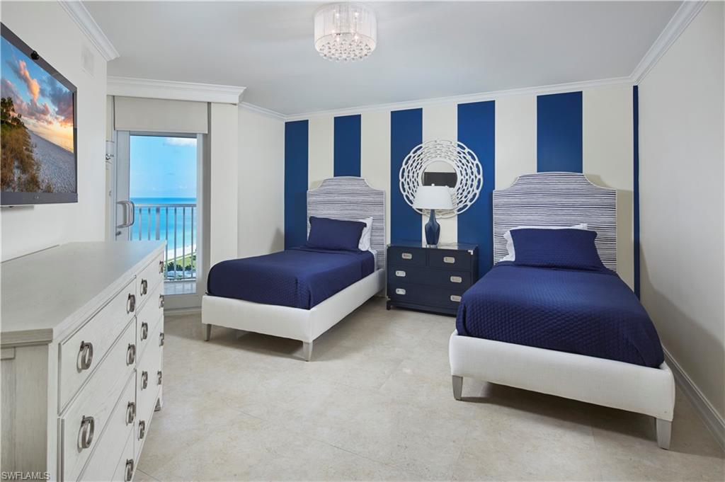 Tiled bedroom with an inviting chandelier, access to exterior, and ornamental molding