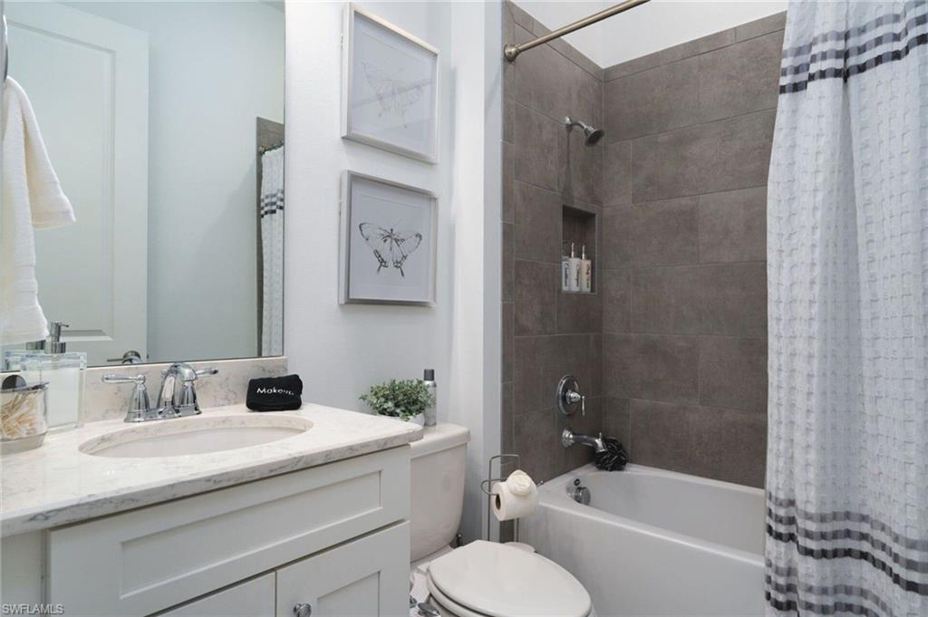 Bathroom featuring a white vanity with an undermount sink, a light-toned countertop, and a chrome faucet