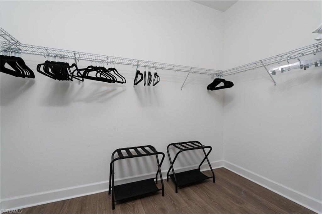 Spacious closet with wire shelving system, white walls, and wood-finish flooring